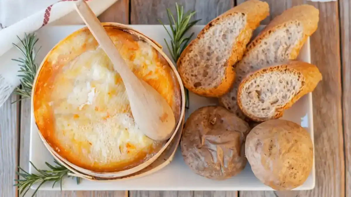 mont d'or au four fondant dans sa boîte en épicéa avec pommes de terre
