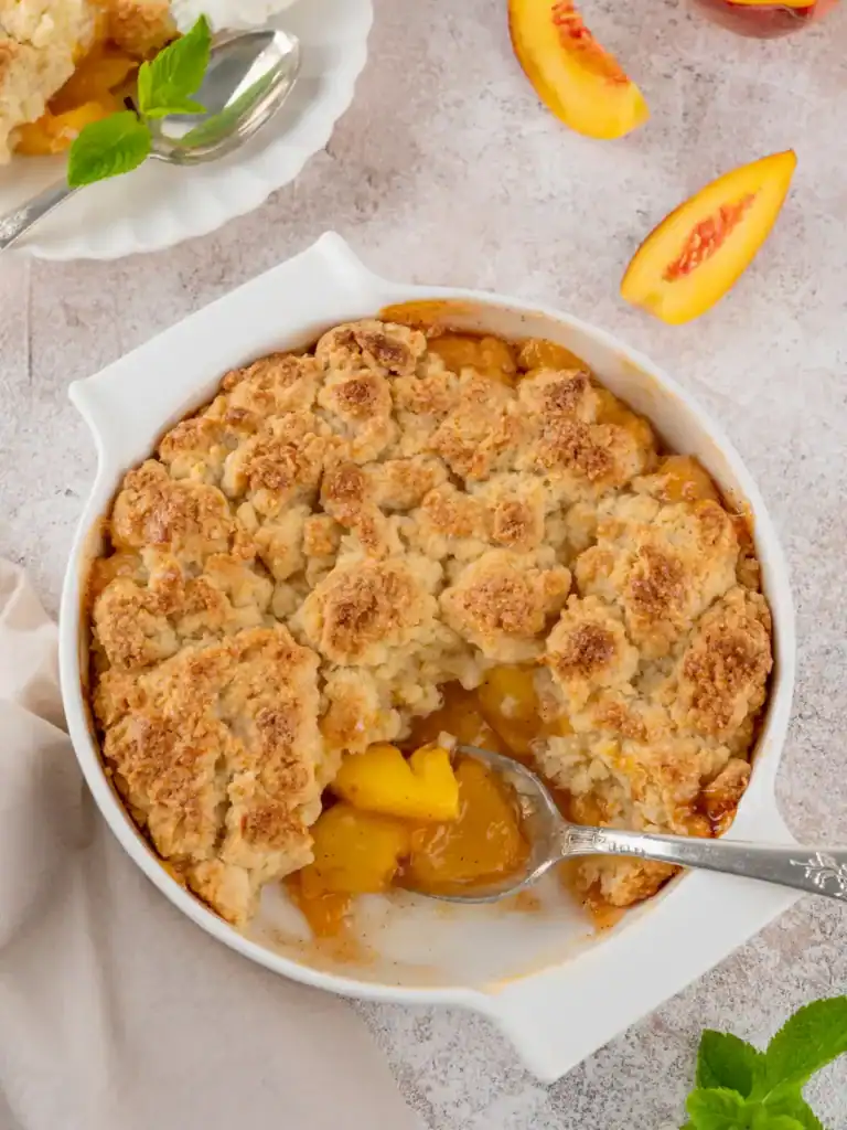 Crumble aux pêches doré, servi tiède directement dans le plat