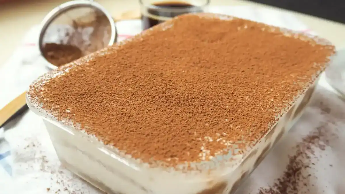 tiramisu au Thermomix dans un plat rectangulaire saupoudré de cacao