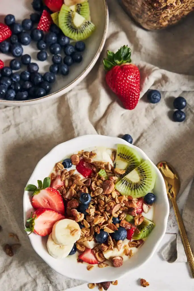 Bol de yaourt nature garni de granola maison et de fruits frais