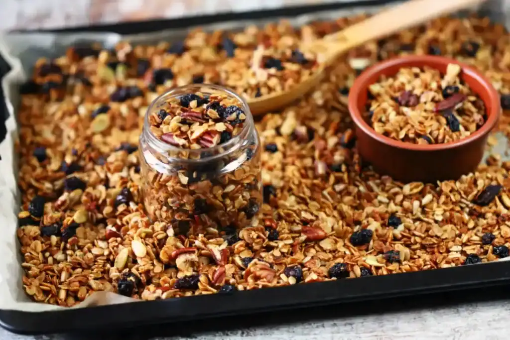Dalle de granola maison tassée sur une plaque avant cuisson au four